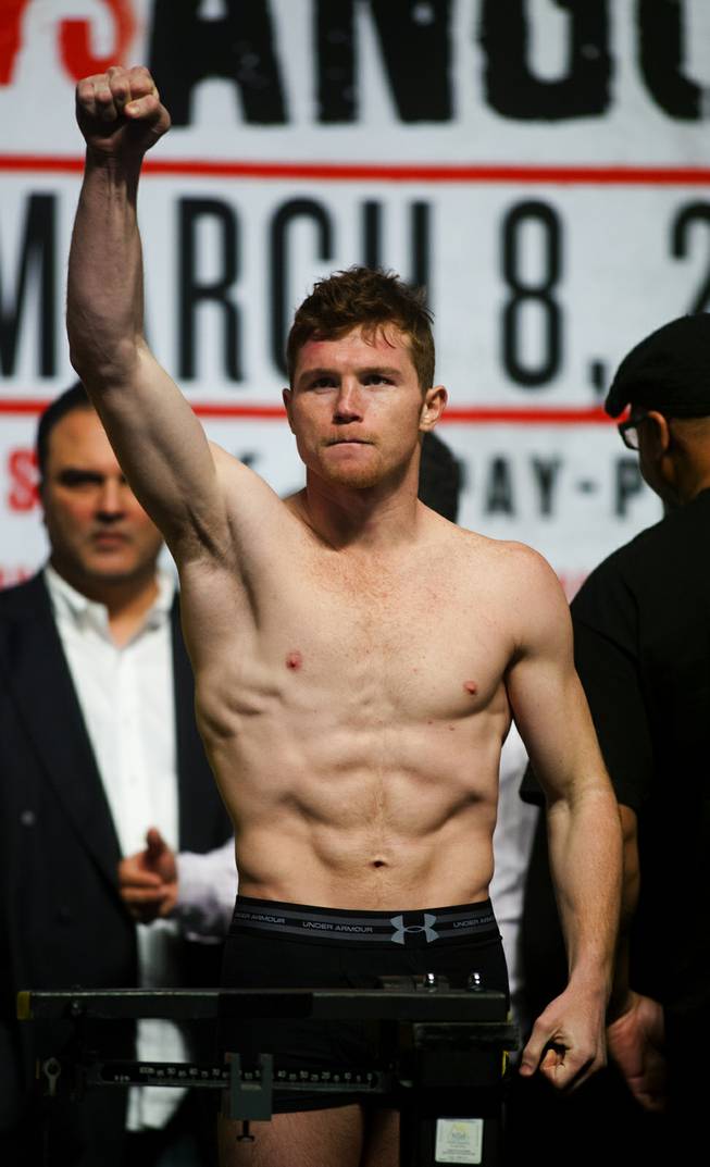Super welterweight Canelo Alvarez of Mexico pumps his fist to the fans on hand for his weigh-in at the MGM Grand Arena on Friday, March 07, 2014.